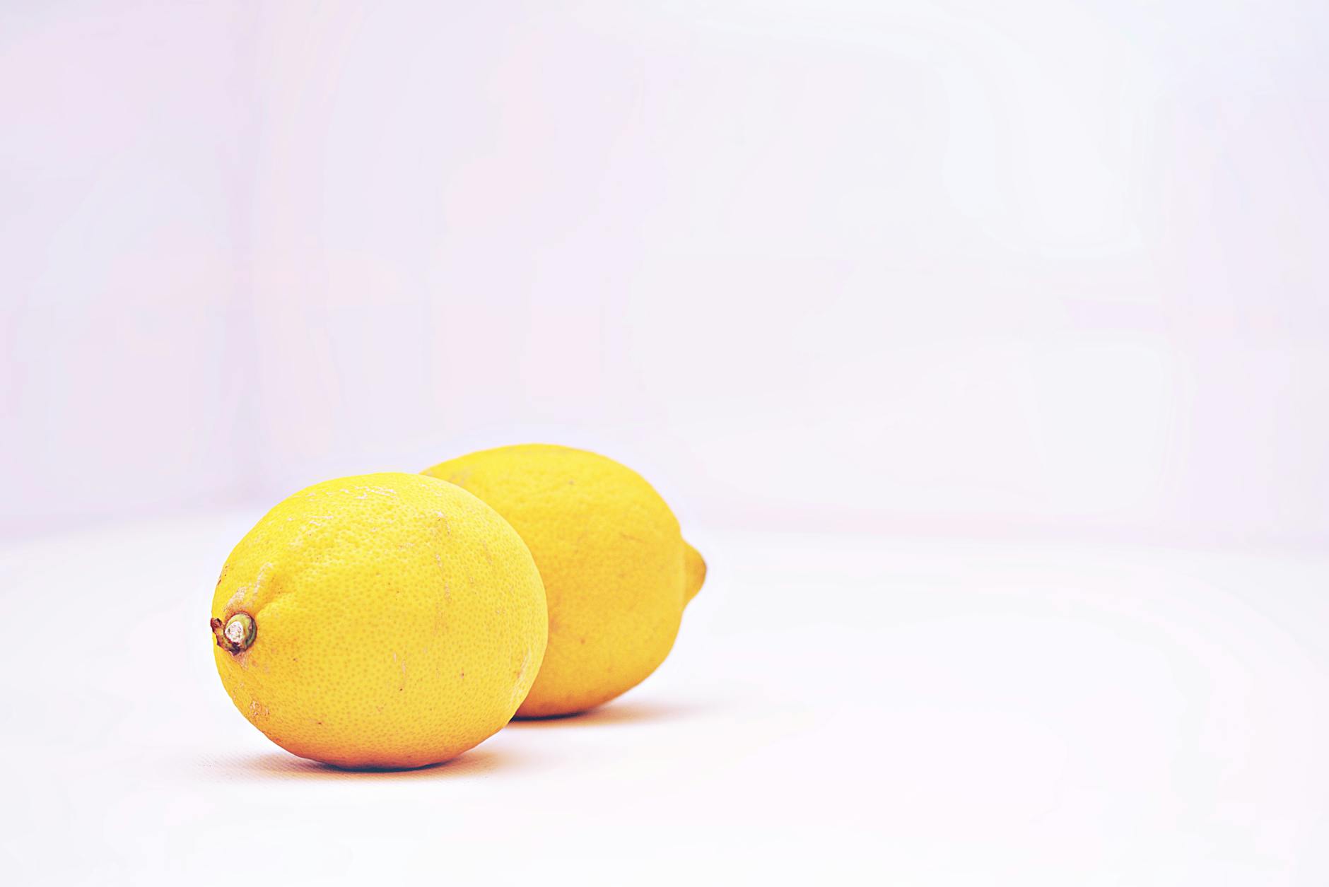 Bright fresh lemons on white background representing clarity and freshness in pleasure