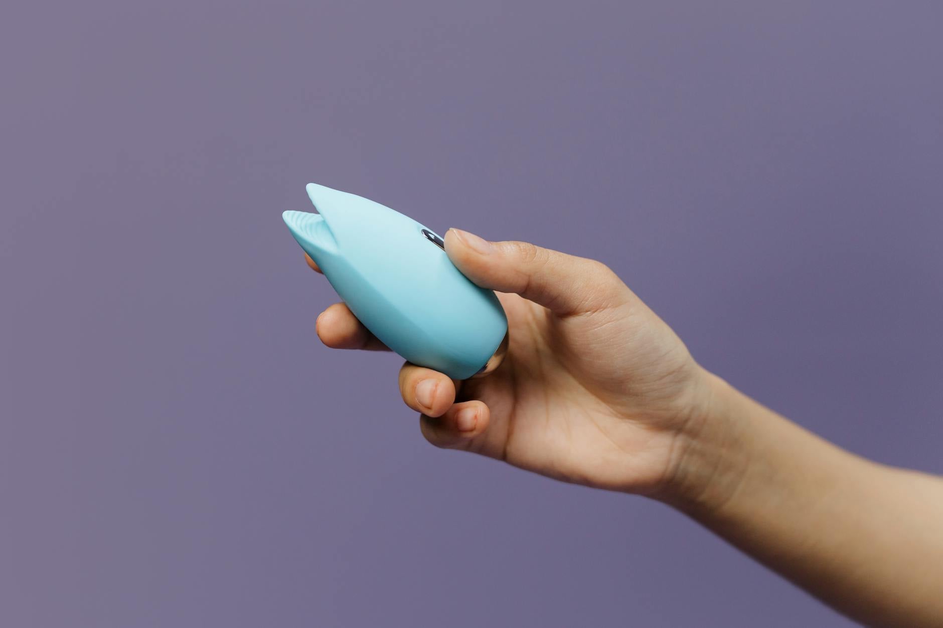 A lemon held in hand against a vivid yellow background, symbolizing fresh pleasure and sensory engagement