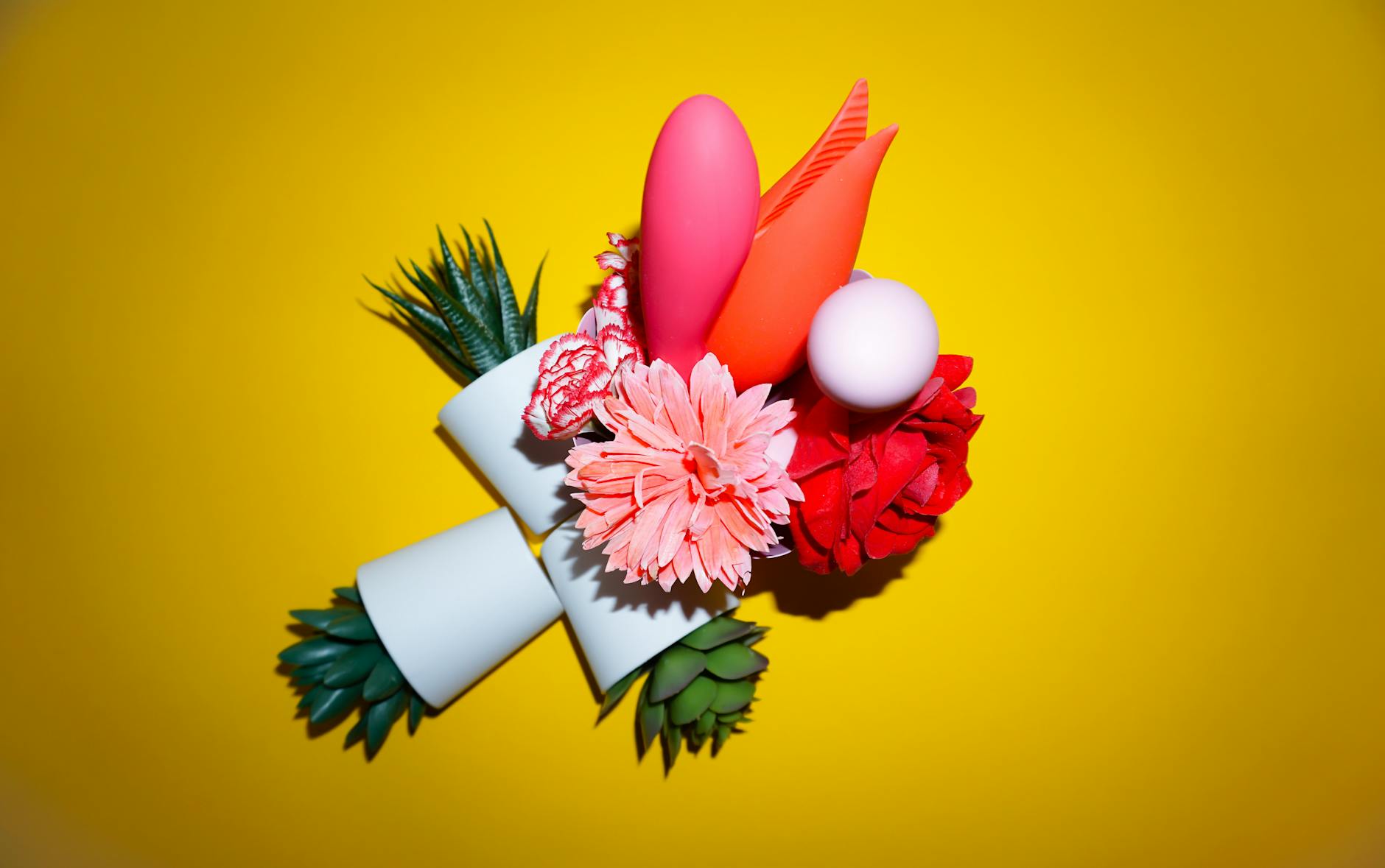 Hand holding a fresh lemon on a pink background, representing natural pleasure and intimacy