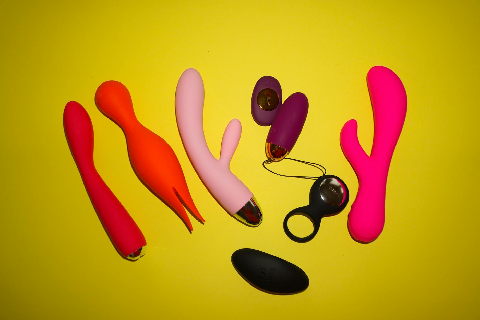 A teal lemon clitoral vibrator resting on smooth white silk fabric
