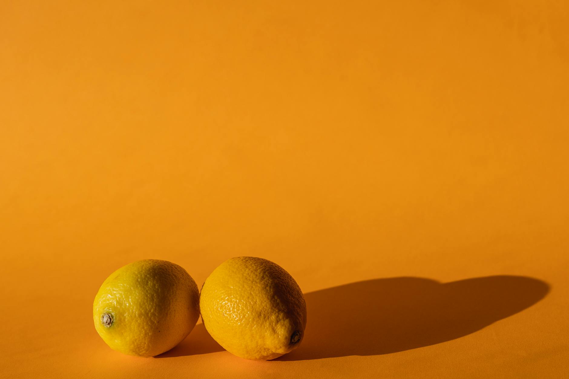 Ripe vivid lemons on a bright yellow background, symbolizing renewal and vitality